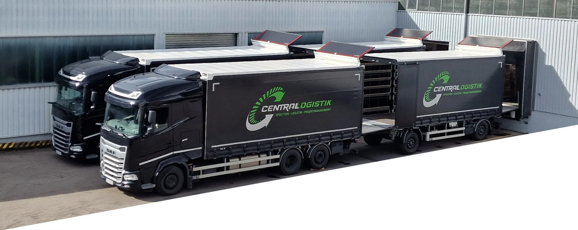 Zwei LKW mit Anhänger der Centrallogistik an der Laderampe